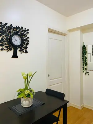 a room with a table with a clock on the wall at cozy and minimalist room near airport in Manila