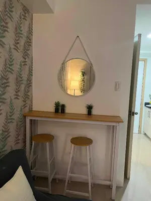 a table with two stools and a mirror on the wall at BH Crib - Staycation near Mall of Asia Complex in Manila