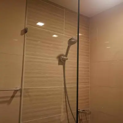 a shower with a shower head in a bathroom at Cozy Pad BGC in Manila