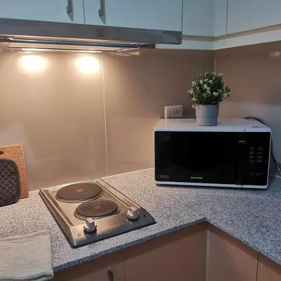 a microwave sitting on top of a kitchen counter at Cozy Pad BGC in Manila