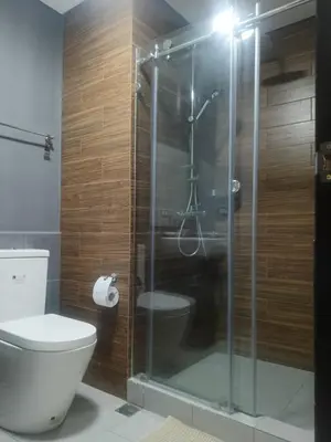 a bathroom with a toilet and a glass shower at The Radiance Manila Bay Studio 2 in Manila