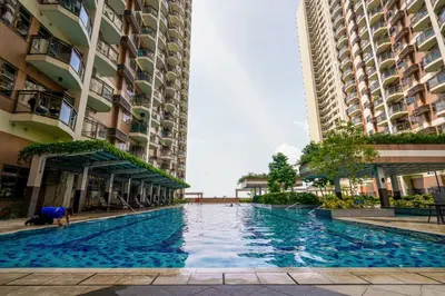 a swimming pool in the middle of two buildings at The Radiance Manila Bay Studio 2 in Manila