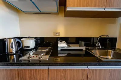 a kitchen with a sink and a stove top oven at The Radiance Manila Bay Studio in Manila