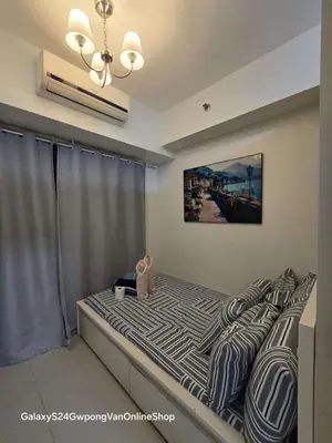 a bed with a teddy bear sitting on top of it at Sea Residences Yeshua infront of MOA Pasay in Manila