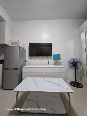 a living room with a tv on a white wall at Sea Residences Yeshua infront of MOA Pasay in Manila