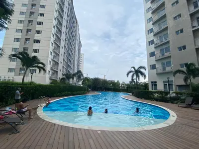 a group of people in a swimming pool with buildings at Hotel Luxury Twin Bed Room with Balcony Las Pinas-South Residence in Manila