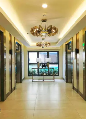 a hallway of a hotel with a chandelier and a large window at Samuel staycation in Smdc Green2 one studio unit in Dasmariñas