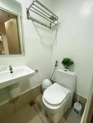 a white bathroom with a toilet and a sink at Samuel staycation in Smdc Green2 one studio unit in Dasmariñas