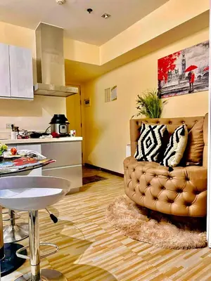 a living room with a brown couch in a kitchen at Azure Urban Resort - St Tropez Tower Staycation Unit with a European Touch in Manila