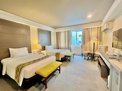 a hotel room with two beds and a desk at 88 Courtyard Hotel in Manila