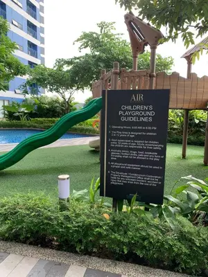 a sign in a park with a slide at Cozy 1-BR Flat in Air Residences Makati in Manila