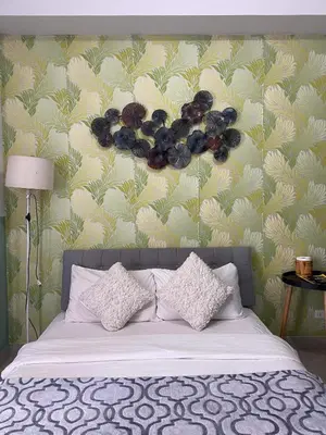 a bedroom with a bed with pillows and a wall at Eco Friendly Studio Rooms Edsa Mandaluyong Shaw at F Residences under New Management in Manila