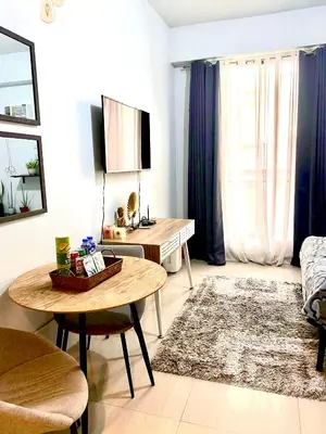 a living room with a table and a couch at Cozy and nature inspired studio rooms Mandaluyong Edsa at F Residences under new management in Manila