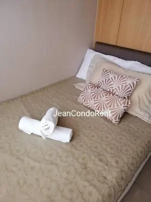 a bed with two towels and pillows on it at Magayon Staycation Shell Residences Mall of Asia in Manila