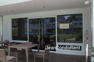 a restaurant with tables and chairs in front of a window at Magayon Staycation Shell Residences Mall of Asia in Manila