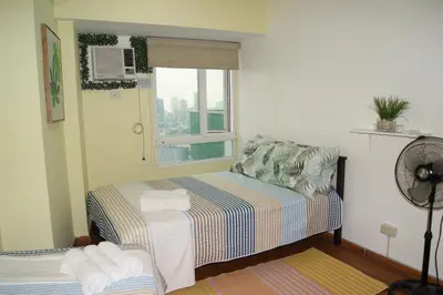 a small room with a bed and a window at The Beacon Makati by mvmtransient in Manila