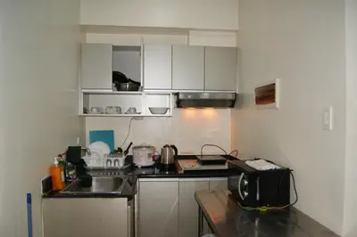 a small kitchen with a sink and a microwave at The Beacon Makati by mvmtransient in Manila