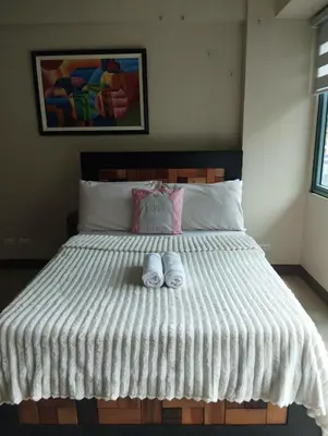 a bedroom with a bed with two slippers on it at Palm Tree Villas in Manila