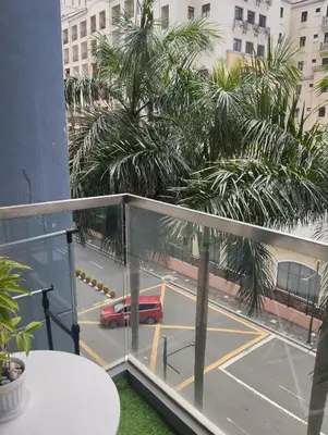 a balcony with a view of a parking lot with a red car at Palm Tree Villas in Manila