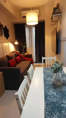 a living room with a table and chairs and a couch at My Humble Abode at Shore 3 in Manila
