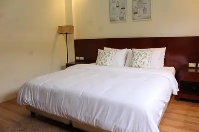 a bedroom with a large bed with white sheets and pillows at MaClare Resort in Imus