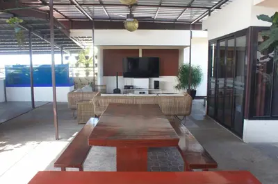 a living room with a wooden table and a tv at MaClare Resort in Imus