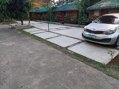 a white car parked on the side of a driveway at MaClare Resort in Imus