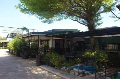 a building with a lot of plants in front of it at MaClare Resort in Imus