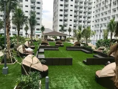 a park with benches and palm trees and buildings at SHORE RESIDENCE D17 shortwalk Mall of asia near airport in Manila