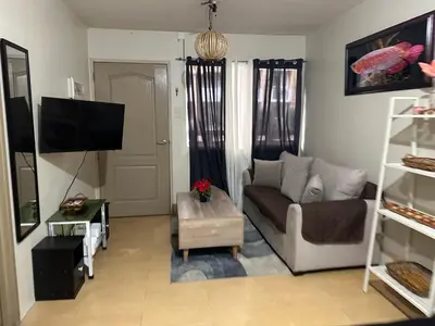a living room with a couch and a tv at B-G Sorento Oasis 2BR in Manila