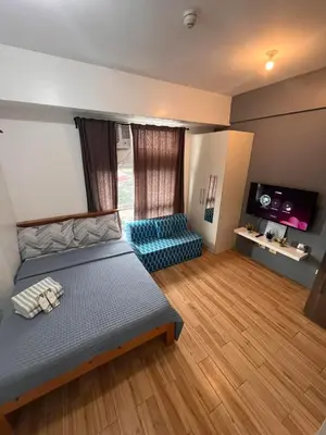 a bedroom with a bed and a flat screen tv at JFam Suites, C3-11D Studio, Up To 4 Pax in Biñan
