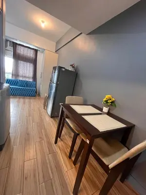 a dining room with a table and a refrigerator at JFam Suites, C3-11D Studio, Up To 4 Pax in Biñan