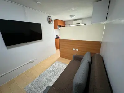 a living room with a couch and a flat screen tv at Condo in Pasig - One Oasis Staycation in Manila