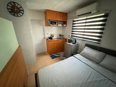 a small room with a bed and a kitchen at Condo in Pasig - One Oasis Staycation in Manila