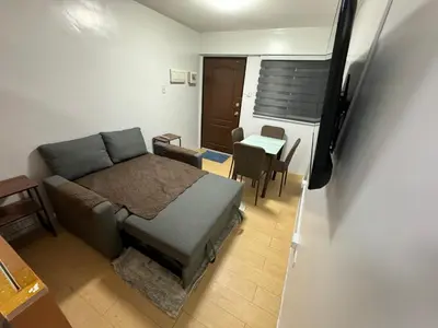 a bedroom with a bed and a table and a dining room at Condo in Pasig - One Oasis Staycation in Manila