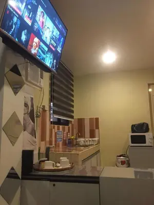 a kitchen with a tv hanging on the wall at Arcobaleno in Manila