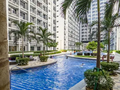 a swimming pool in the middle of a building with palm trees at GemstoneBR in SMDC Shore 2 Residences in Manila