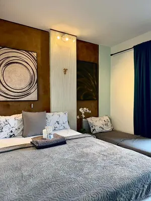a bedroom with a large bed with a blue curtain at Cinema room at Intramuros by IN cafebar in Manila
