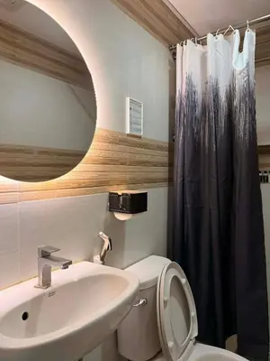 a bathroom with a sink and a toilet and a mirror at Cinema room at Intramuros by IN cafebar in Manila