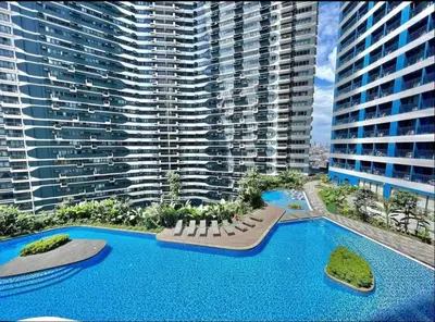 an aerial view of a large building with a swimming pool at Cozy Condo Apartment in Makati / Manila with mall, restaurants, groceries, pool, netflix, disney+ and more in Manila