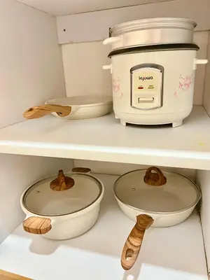 a kitchen with three bowls and a toaster on a shelf at Sea Residences: Eyal’s Suite Condotel near MOA/Mall of Asia in Manila