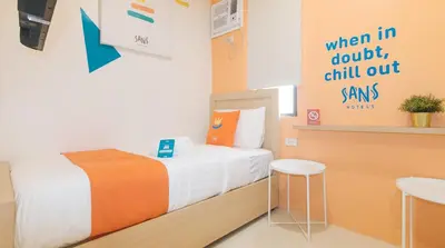a small room with a bed and stools in it at Sans Hotel at One JD Place Makati by RedDoorz in Manila