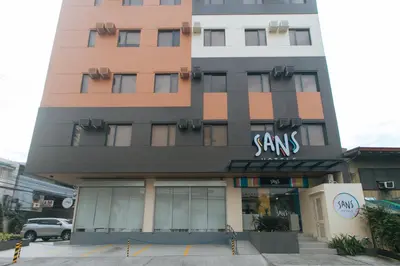 a tall building with a samsams sign on it at Sans Hotel at One JD Place Makati by RedDoorz in Manila