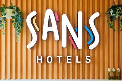 a sign for a hotel with plants on a wall at Sans Hotel at One JD Place Makati by RedDoorz in Manila