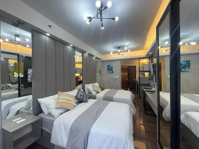 a bedroom with three beds and a bathroom at Cozy Family Nook at Makati in Manila