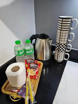a kitchen counter with a counter top with some food and water at Jamellas' Smile Home in Manila