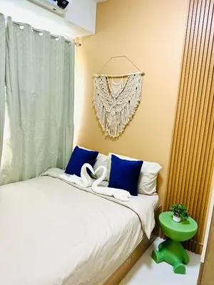 a bedroom with a bed with two swans on it at Chic and Cozy 1BR Shore 3 by SMDC near MOA in Manila