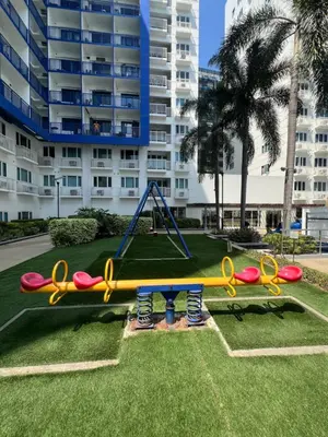a playground in a park in front of a building at 2BR Staycation in front of MOA Near Aiports Entertainment City Ayala Malls Parqal Worldtrade Center PICC Starcity SEA ESCAPE BLISS in Manila