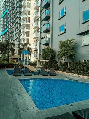 a swimming pool in front of a tall building at The Bat Cave 2 at Manhattan Heights Araneta Cubao in Manila