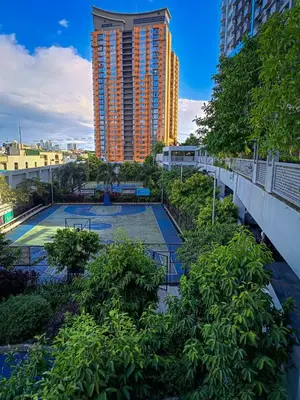 a tennis court in front of a tall building at The Bat Cave 2 at Manhattan Heights Araneta Cubao in Manila